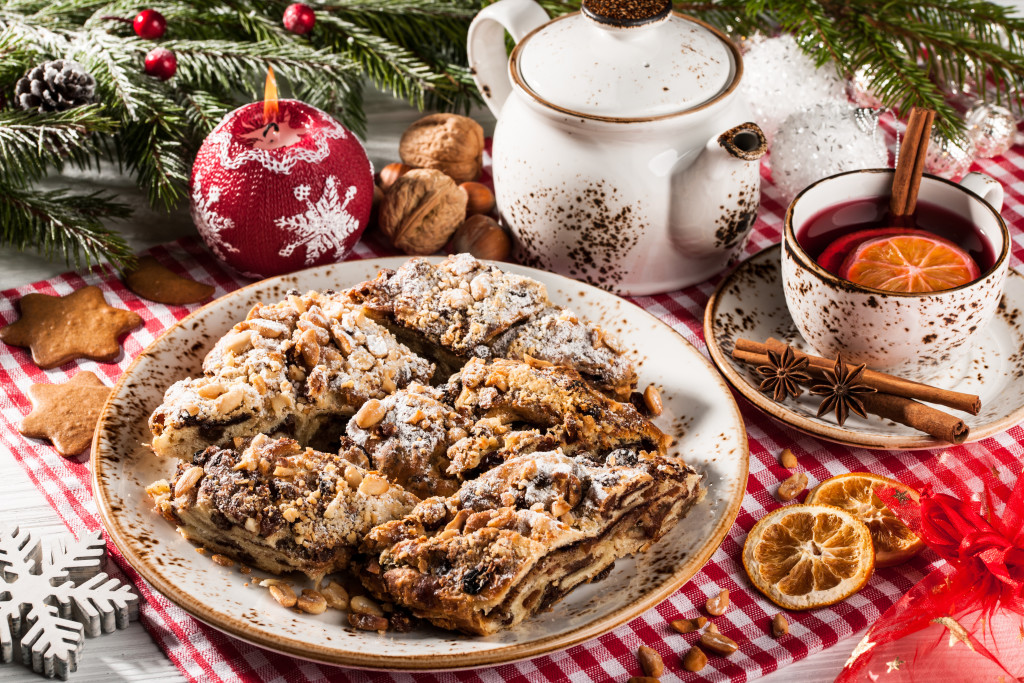 Holiday cookies with ornaments in the back and a mug with tea in it.