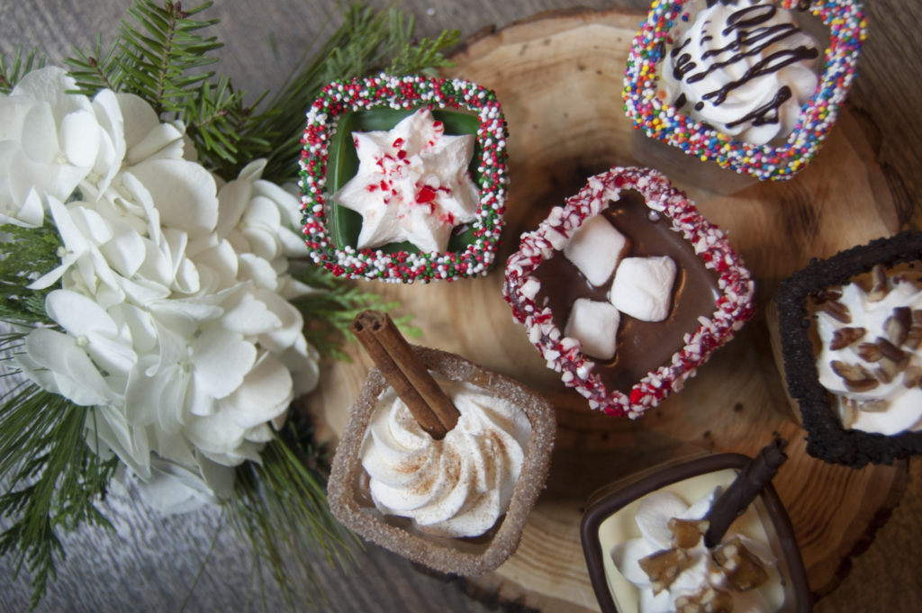 Overhead shot of milkshakes with different toppings on them.