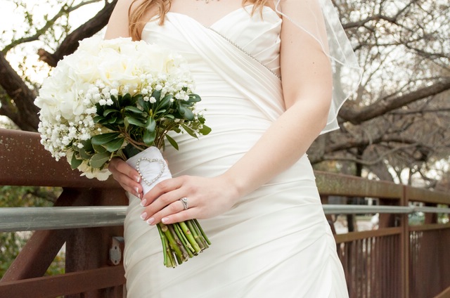 A bride in a wedding dress holding a bouquet.