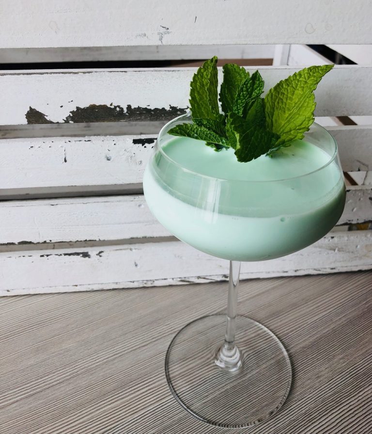 An alcoholic beverage in a specialty cocktail glass.