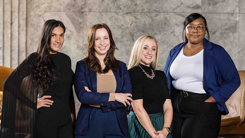 Meet the Workplace Dining Team - Blue Plate's workplace dining team standing and smiling in front of a marble fireplace.