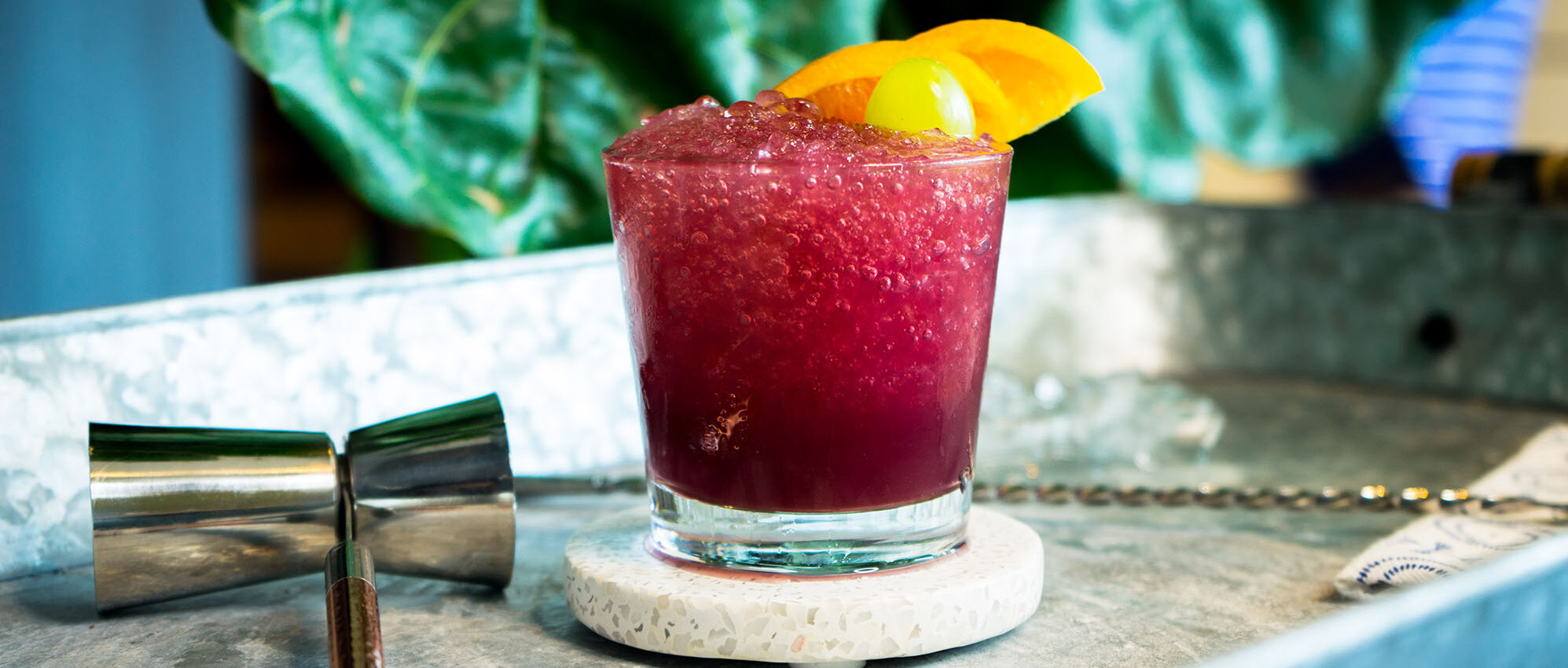 Red wine sangria slushie in short glass with orange slice