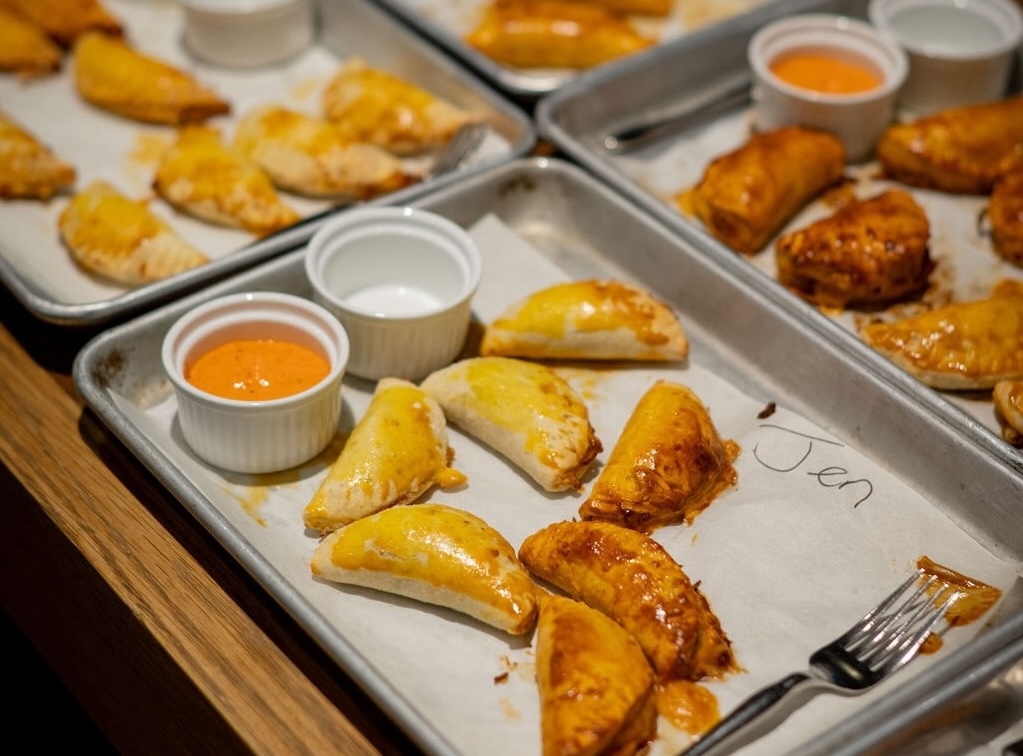 Empanadas on a tray with sauces.